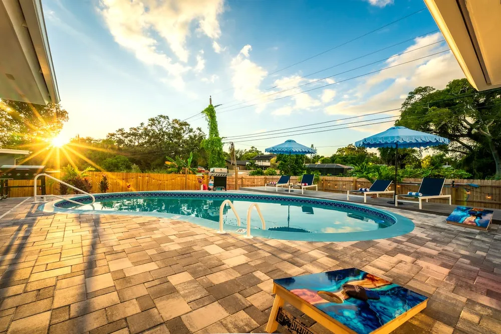 Pool at golden hour with cornhole boards