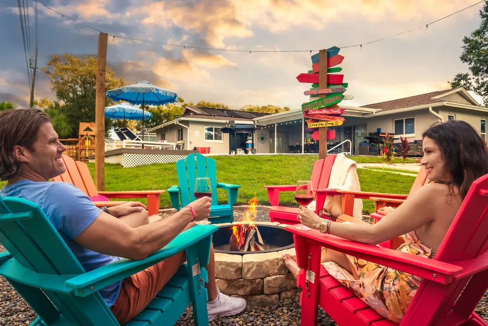 Couple relaxing by fire pit at sunset