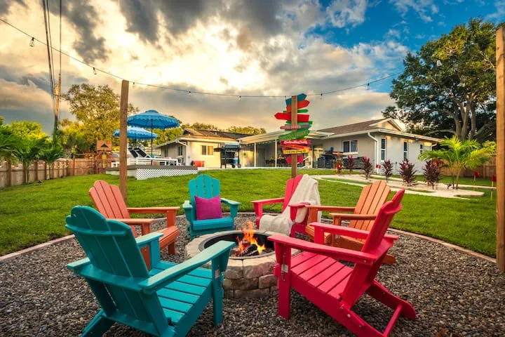 Colorful Adirondack chairs around fire pit at sunset