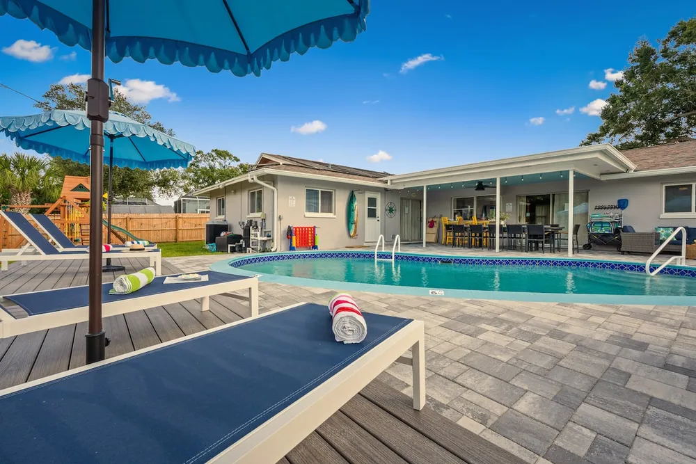 Full backyard view with pool, deck, and playground