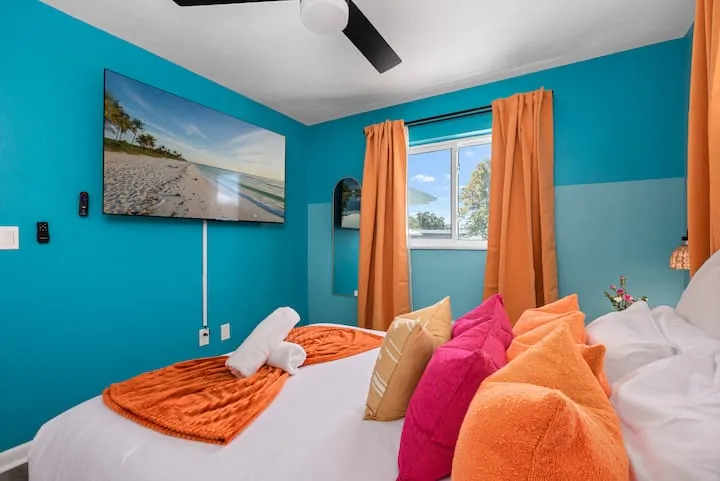 Queen bedroom TV and colorful pillows