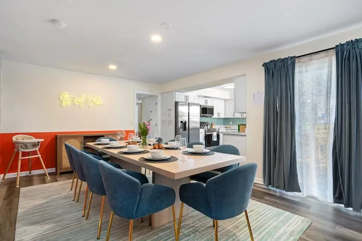 Dining area with neon sign and kitchen view