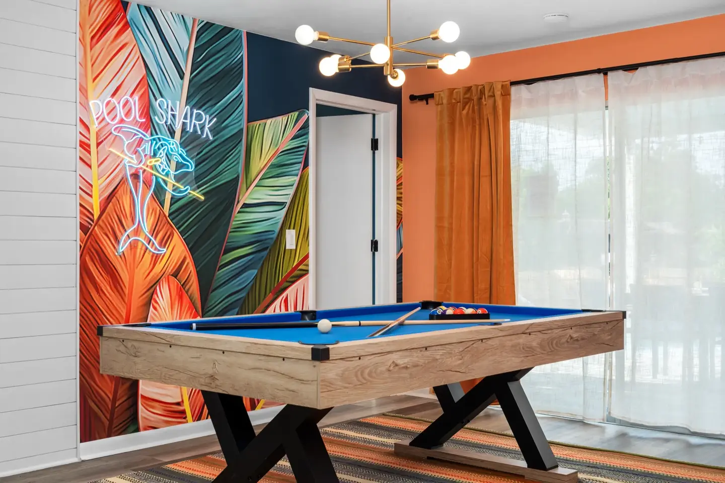 Pool table with tropical mural and Pool Shark neon sign at Chasing Vitamin Sea