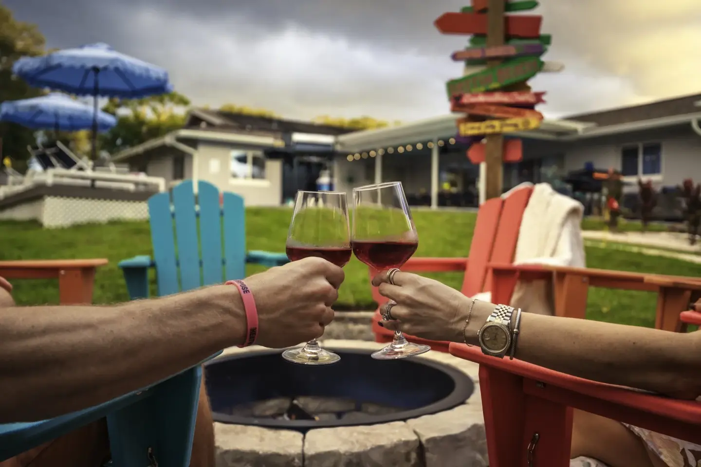 Two guests clinking wine glasses at the fire pit at Chasing Vitamin Sea
